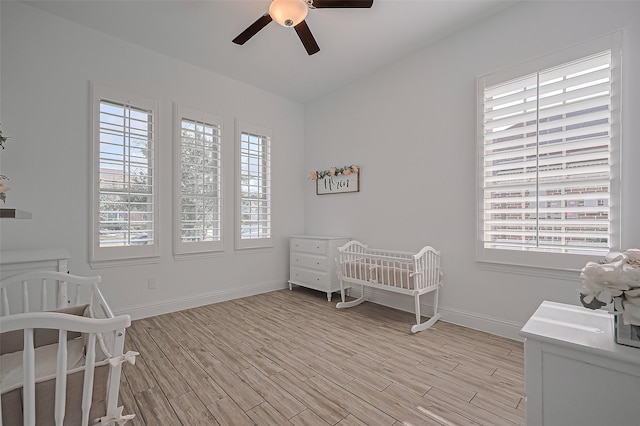18003 Winding Willow Oak Way, Cypress, TX 77433 - bedroom with a crib, multiple windows, light wood-style flooring, and ceiling fan