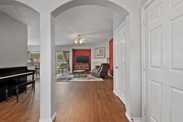 6403 Sagewalk Ct, Spring, TX 77379 - hall featuring arched walkways, wood finished floors, baseboards, and a textured ceiling