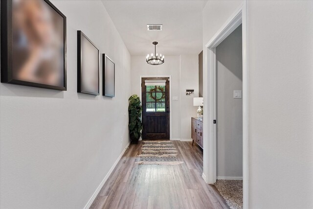 16997 White Birch Ln, Conroe, TX 77385 - doorway with a chandelier, wood finished floors, and baseboards