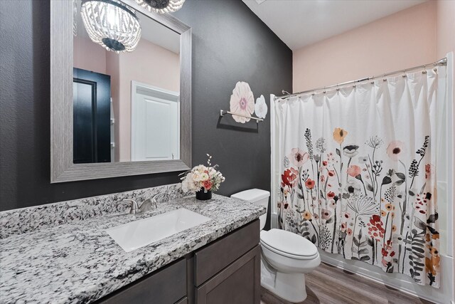 16997 White Birch Ln, Conroe, TX 77385 - bathroom with wood finished floors, toilet, vanity, and a chandelier