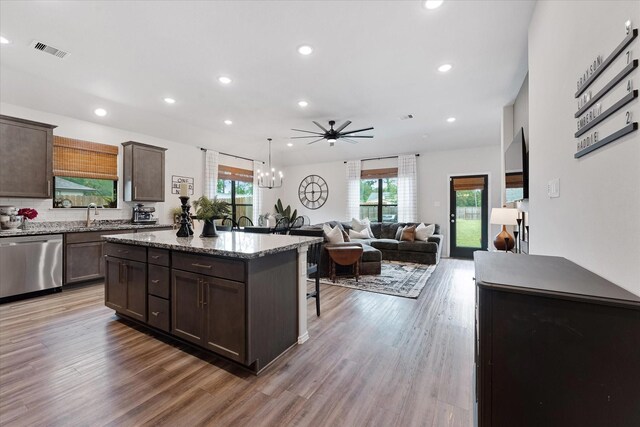 16997 White Birch Ln, Conroe, TX 77385 - kitchen with dishwasher, dark brown cabinetry, a center island, a kitchen breakfast bar, and recessed lighting