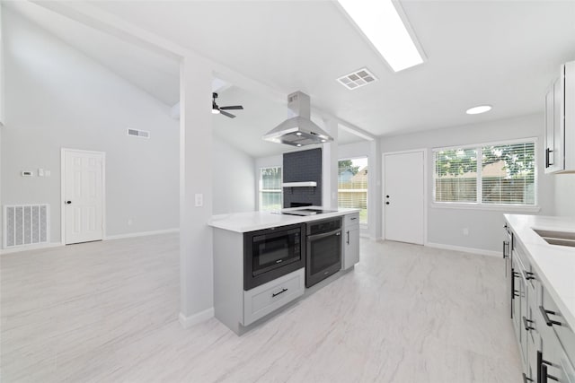 7211 Autumn Grove Dr, Houston, TX 77072 - kitchen with island exhaust hood, black appliances, light countertops, lofted ceiling, and baseboards