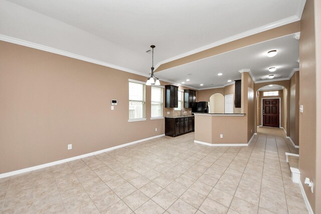 7714 Guldan Dr, Richmond, TX 77407 - kitchen with arched walkways, light tile patterned floors, ornamental molding, freestanding refrigerator, and open floor plan