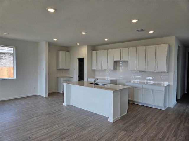 10611 Autumn Trace Dr, Beasley, TX 77417 - kitchen with tasteful backsplash, dark wood-style flooring, a kitchen island with sink, baseboards, and a sink