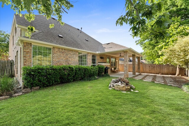 31318 Bearing Star Ln, Tomball, TX 77375 - back of house with an outdoor fire pit, a patio area, roof with shingles, and brick siding