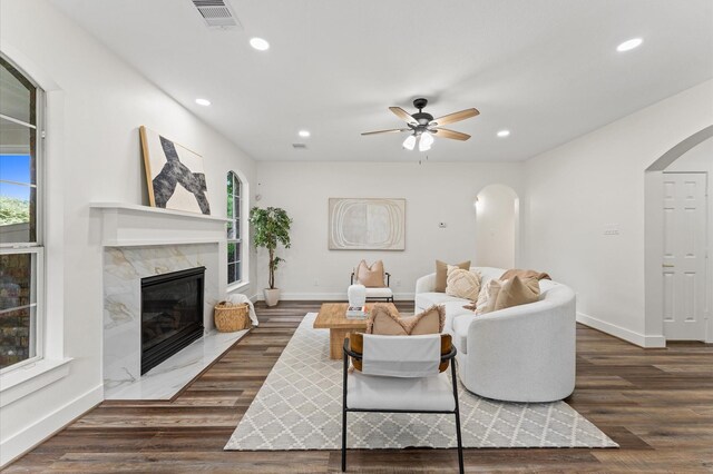 31318 Bearing Star Ln, Tomball, TX 77375 - living room with arched walkways, baseboards, wood finished floors, recessed lighting, and a premium fireplace