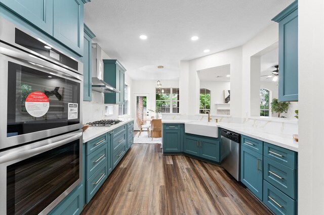 31318 Bearing Star Ln, Tomball, TX 77375 - kitchen featuring stainless steel appliances, a sink, dark wood-style flooring, recessed lighting, and blue cabinetry