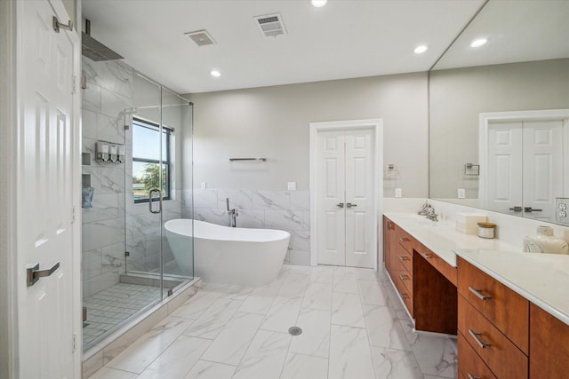 1814 Rosalie St, Houston, TX 77004 - bathroom with a marble finish shower, vanity, a freestanding bath, marble look tiles, and tile walls