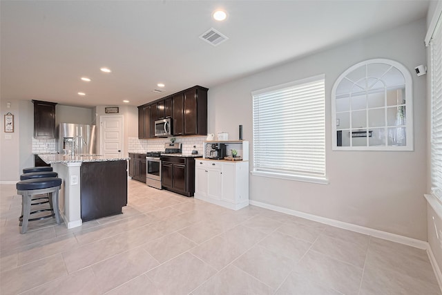 3415 Sicily Island Ln, Katy, TX 77494 - kitchen with appliances with stainless steel finishes, tasteful backsplash, light stone counters, recessed lighting, and plenty of natural light