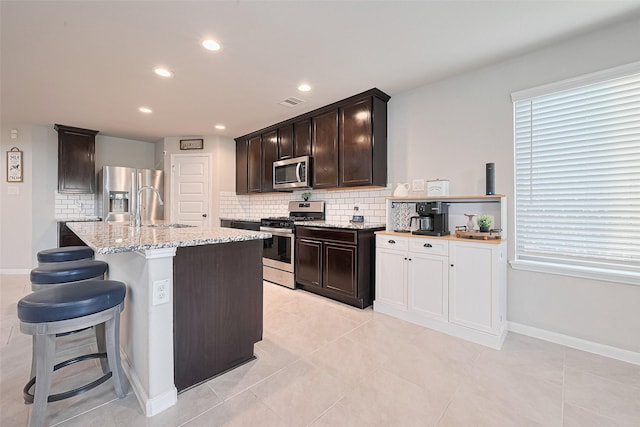 3415 Sicily Island Ln, Katy, TX 77494 - kitchen featuring stainless steel appliances, a sink, tasteful backsplash, light stone countertops, and baseboards
