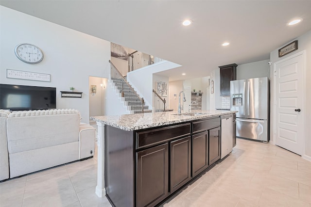 3415 Sicily Island Ln, Katy, TX 77494 - kitchen with appliances with stainless steel finishes, a sink, open floor plan, light tile patterned floors, and dark brown cabinetry