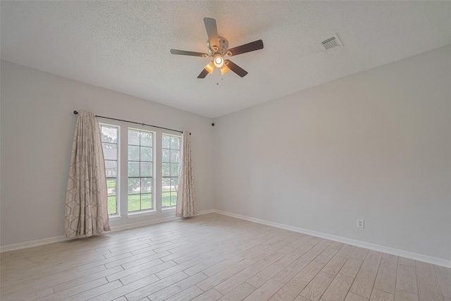 5210 Holly View Dr, Houston, TX 77091 - empty room featuring light wood-style flooring, a ceiling fan, a textured ceiling, and baseboards
