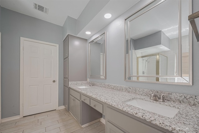 5210 Holly View Dr, Houston, TX 77091 - full bathroom with double vanity, a stall shower, wood tiled floors, recessed lighting, and baseboards