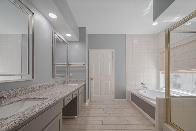 5210 Holly View Dr, Houston, TX 77091 - bathroom featuring double vanity, a garden tub, recessed lighting, and baseboards