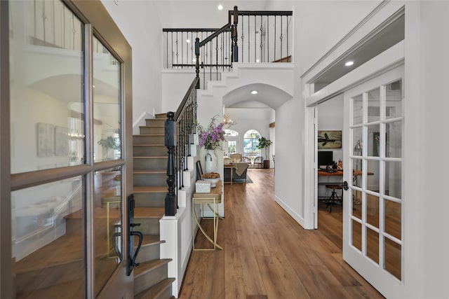 22810 Glenmont Estates Blvd, Magnolia, TX 77355 - entryway with arched walkways, stairway, wood-type flooring, a high ceiling, and french doors