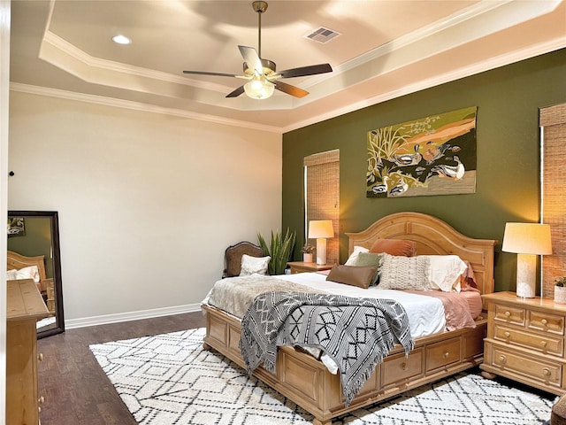1549 Frontier Trl, Angleton, TX 77515 - bedroom featuring a tray ceiling, crown molding, wood finished floors, ceiling fan, and baseboards