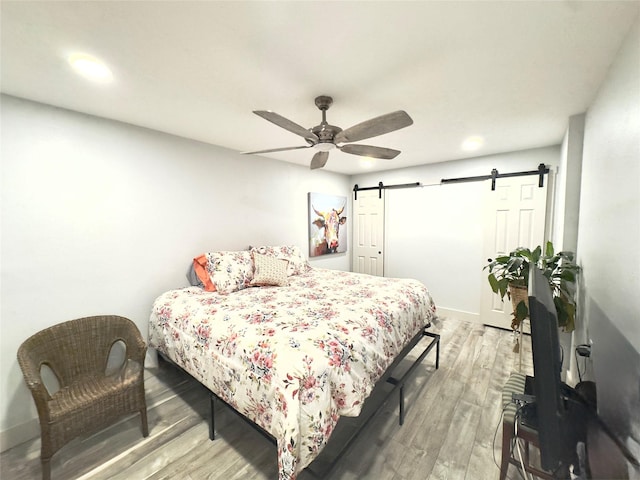5301 Hemlock Dr, Baytown, TX 77521 - bedroom featuring a barn door, wood finished floors, a ceiling fan, recessed lighting, and baseboards