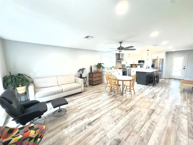 5301 Hemlock Dr, Baytown, TX 77521 - living area featuring light wood-style flooring, healthy amount of natural light, recessed lighting, a ceiling fan, and baseboards