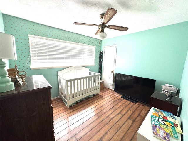 5301 Hemlock Dr, Baytown, TX 77521 - bedroom featuring hardwood / wood-style flooring, ceiling fan, and a textured ceiling