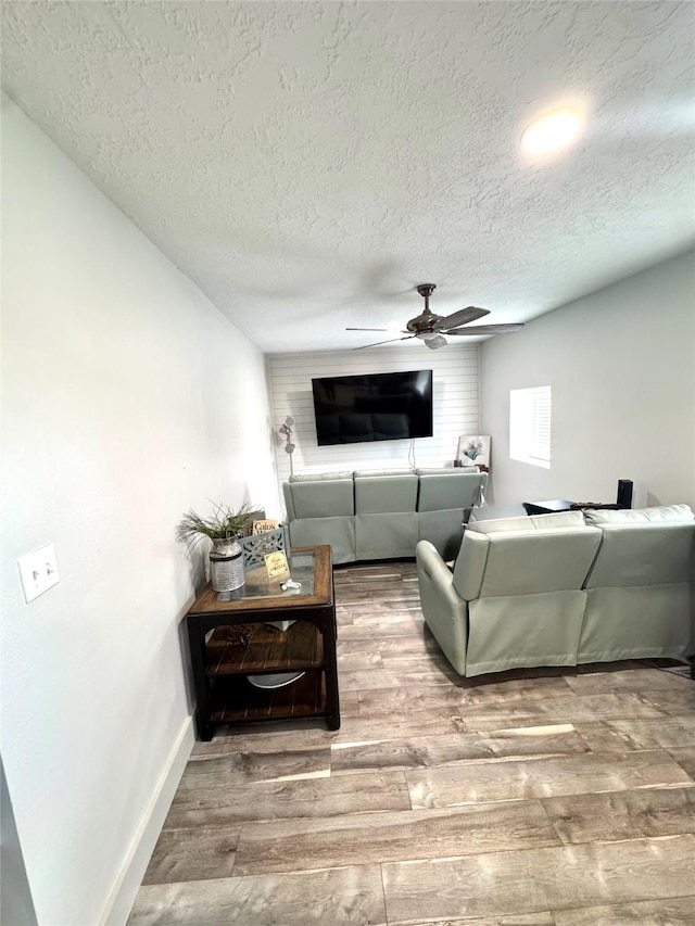 5301 Hemlock Dr, Baytown, TX 77521 - living room featuring a textured ceiling, a ceiling fan, wood finished floors, and baseboards