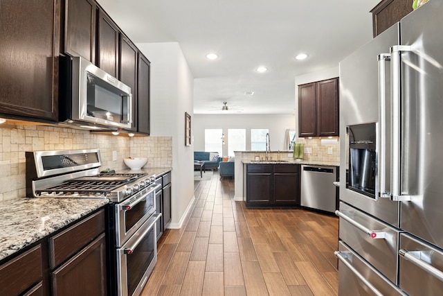 3519 Barkers Run Dr, Houston, TX 77084 - kitchen featuring appliances with stainless steel finishes, a sink, a ceiling fan, dark brown cabinets, and recessed lighting