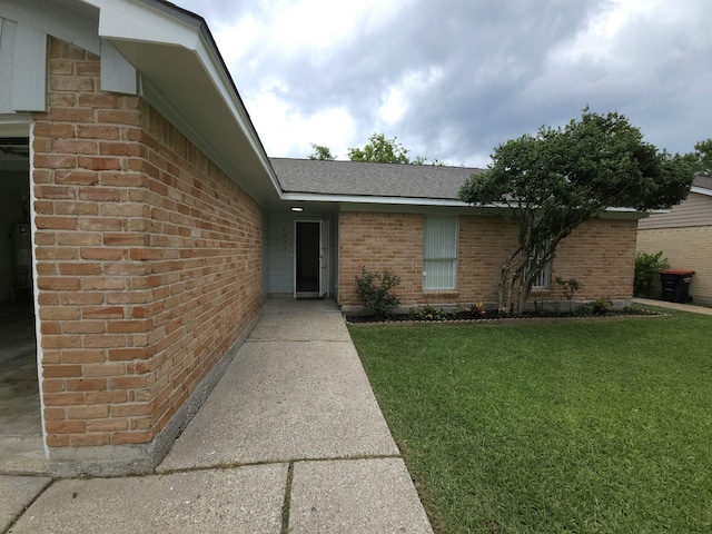 2806 W Greens Rd, Houston, TX 77067 - property entrance featuring brick siding, a yard, and roof with shingles