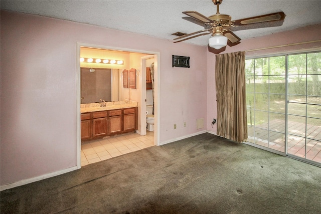 21 Edgewood Forest Ct, The Woodlands, TX 77381 - unfurnished bedroom with access to exterior, light colored carpet, baseboards, a textured ceiling, and light tile patterned flooring
