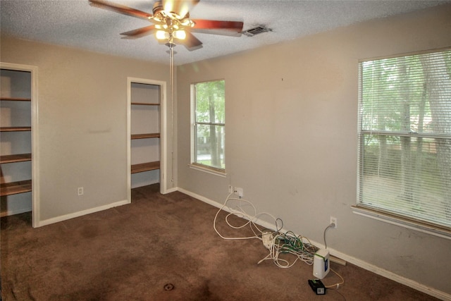 21 Edgewood Forest Ct, The Woodlands, TX 77381 - unfurnished bedroom with a textured ceiling, dark carpet, baseboards, and a ceiling fan