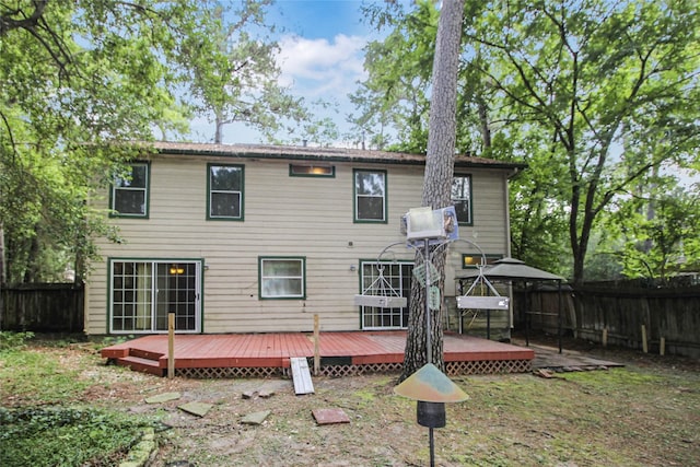 21 Edgewood Forest Ct, The Woodlands, TX 77381 - back of property featuring a wooden deck and a fenced backyard