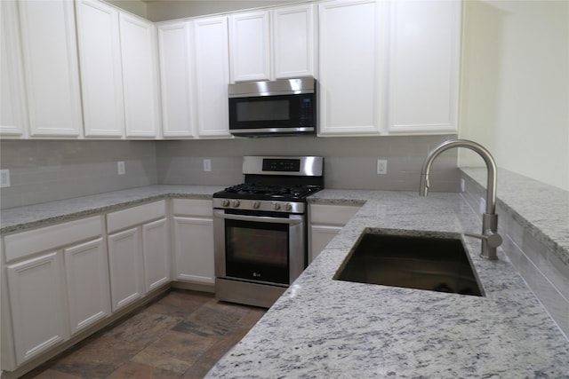 18926 Gentle Cove Ct, Houston, TX 77084 - kitchen with appliances with stainless steel finishes, a sink, decorative backsplash, white cabinets, and light stone countertops