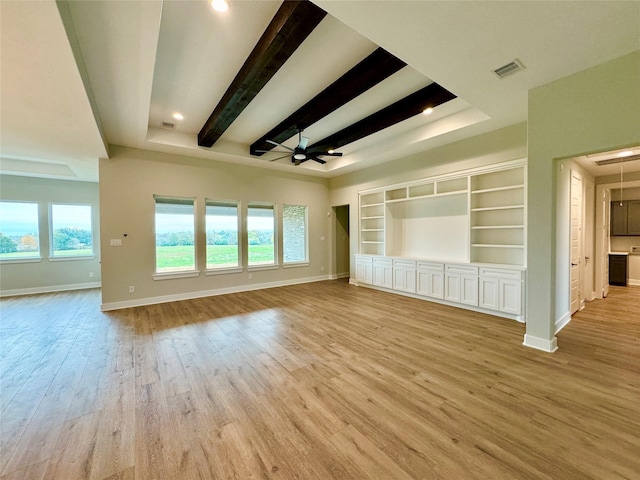 197 Sandpiper Dr, New Waverly, TX 77358 - unfurnished living room with ceiling fan, healthy amount of natural light, wood finished floors, baseboards, and beam ceiling
