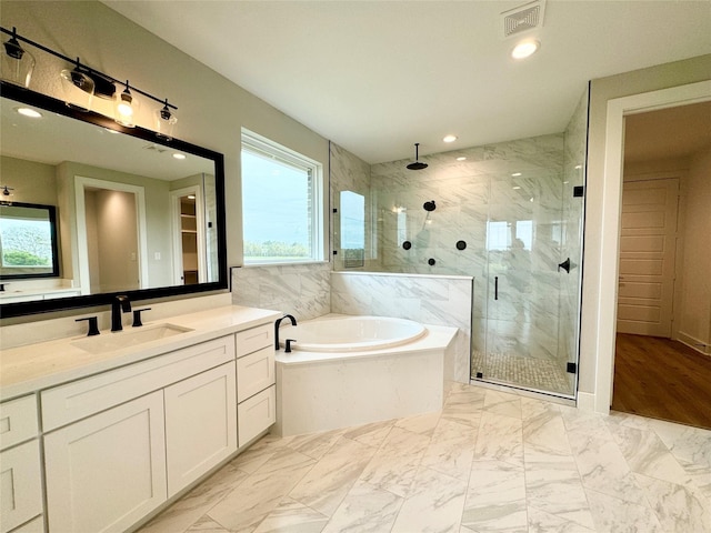 197 Sandpiper Dr, New Waverly, TX 77358 - full bathroom with a garden tub, vanity, a marble finish shower, recessed lighting, and marble look tiles