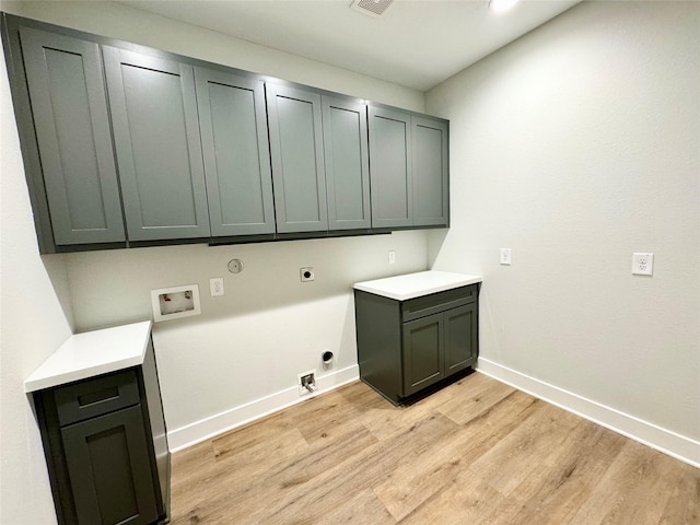 197 Sandpiper Dr, New Waverly, TX 77358 - laundry room with cabinet space, hookup for an electric dryer, light wood-type flooring, baseboards, and washer hookup
