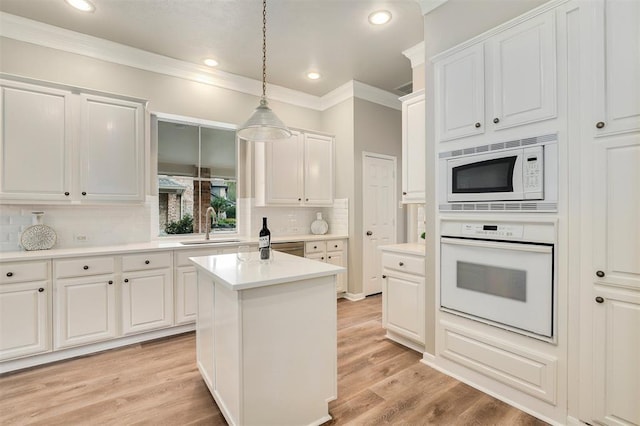 14810 Cantwell Bnd, Cypress, TX 77429 - kitchen with white appliances, a sink, crown molding, decorative backsplash, and white cabinetry