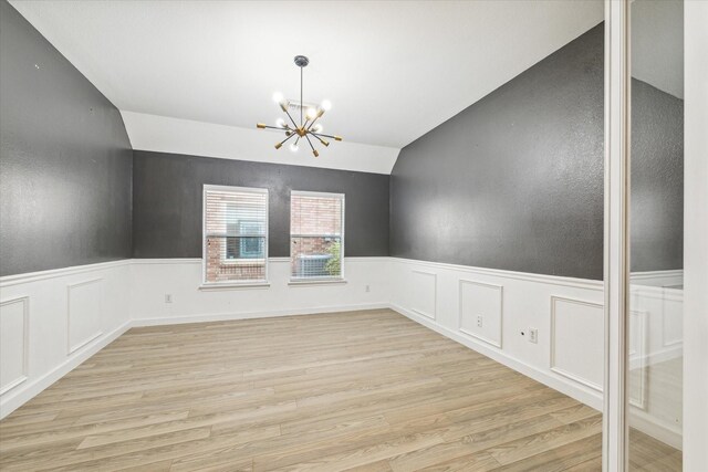 28519 Peper Hollow Ln, Spring, TX 77386 - unfurnished dining area featuring a chandelier, lofted ceiling, light wood-style floors, and a wainscoted wall
