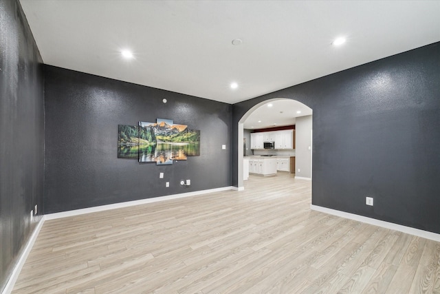 28519 Peper Hollow Ln, Spring, TX 77386 - spare room featuring arched walkways, light wood finished floors, recessed lighting, and baseboards