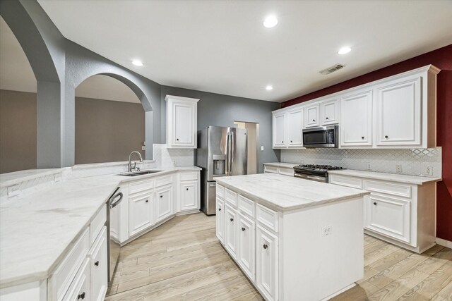 28519 Peper Hollow Ln, Spring, TX 77386 - kitchen with appliances with stainless steel finishes, a sink, tasteful backsplash, light wood-style flooring, and light stone counters