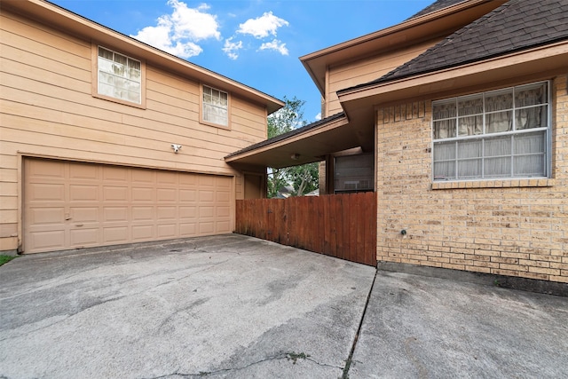15118 Terrace Oaks Dr, Houston, TX 77068 - view of property exterior with brick siding, an attached garage, driveway, and a shingled roof