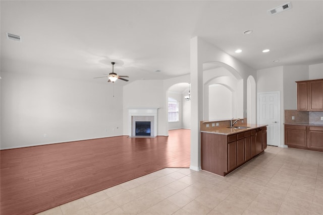 13406 Georgia Hollow Ct, Rosharon, TX 77583 - kitchen with a sink, ceiling fan, tasteful backsplash, recessed lighting, and arched walkways
