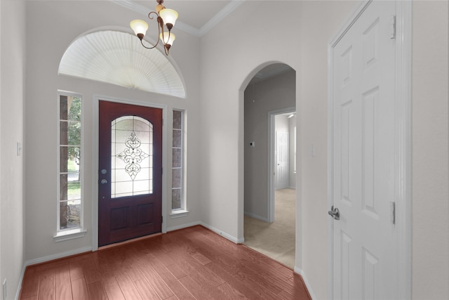 13406 Georgia Hollow Ct, Rosharon, TX 77583 - foyer with arched walkways, a chandelier, baseboards, ornamental molding, and wood finished floors