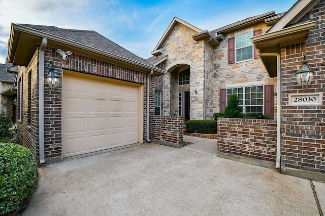 28030 Sugarside Glen Dr, Katy, TX 77494 - view of front facade featuring a garage, concrete driveway, and stone siding