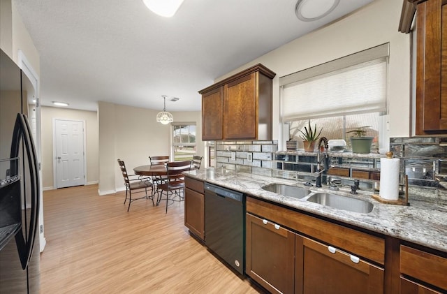 317 Green Isle Ave, Dickinson, TX 77539 - kitchen with black appliances, a sink, light wood-type flooring, and light stone countertops
