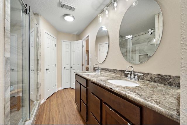 317 Green Isle Ave, Dickinson, TX 77539 - full bathroom with wood finished floors, double vanity, and a stall shower
