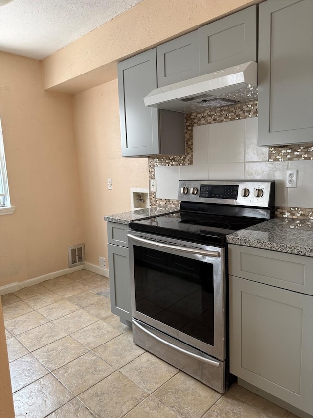 9350 Country Creek Dr Unit 1, Houston, TX 77036 - kitchen featuring stainless steel range with electric stovetop, gray cabinets, range hood, backsplash, and a textured ceiling