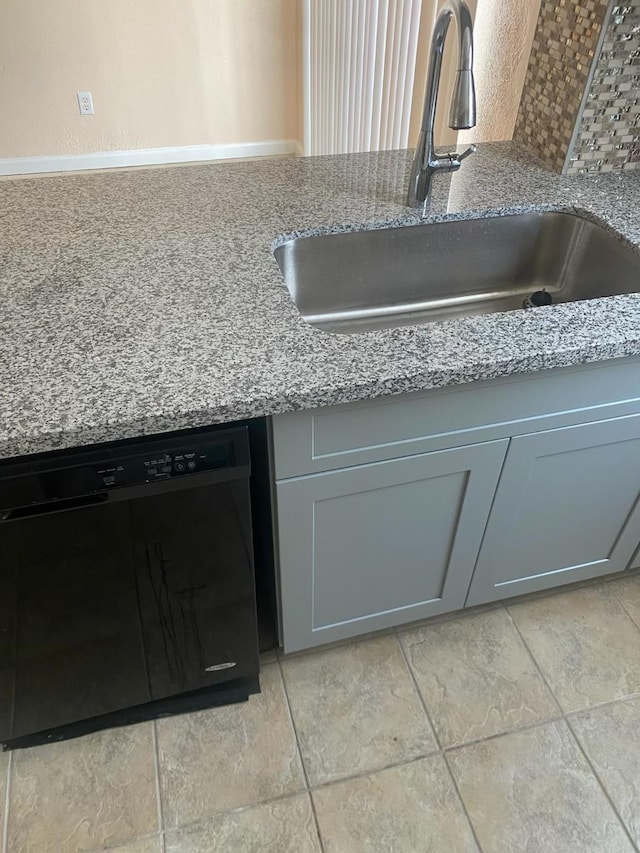 9350 Country Creek Dr Unit 1, Houston, TX 77036 - kitchen view of black dishwasher, a sink, light stone counters, and gray cabinets