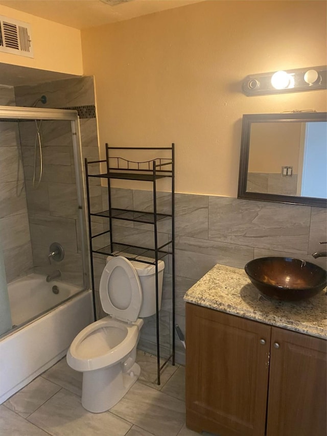 9350 Country Creek Dr Unit 1, Houston, TX 77036 - full bath featuring vanity, shower / bath combination with glass door, toilet, tile walls, and tile patterned flooring