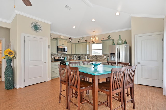 839 S Monkhouse Dr, Crystal Beach, TX 77650 - dining room with light wood finished floors, a chandelier, vaulted ceiling, crown molding, and recessed lighting