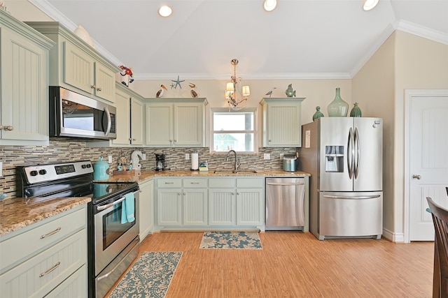 839 S Monkhouse Dr, Crystal Beach, TX 77650 - kitchen with stainless steel appliances, a sink, vaulted ceiling, a chandelier, and backsplash