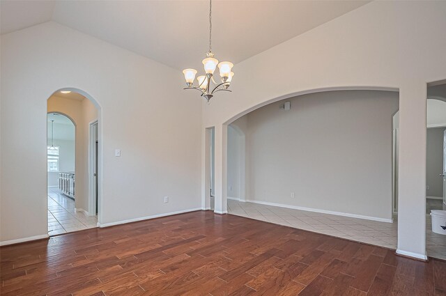 3934 Medici Ct, Missouri City, TX 77459 - spare room featuring wood tiled floors, a chandelier, arched walkways, and high vaulted ceiling