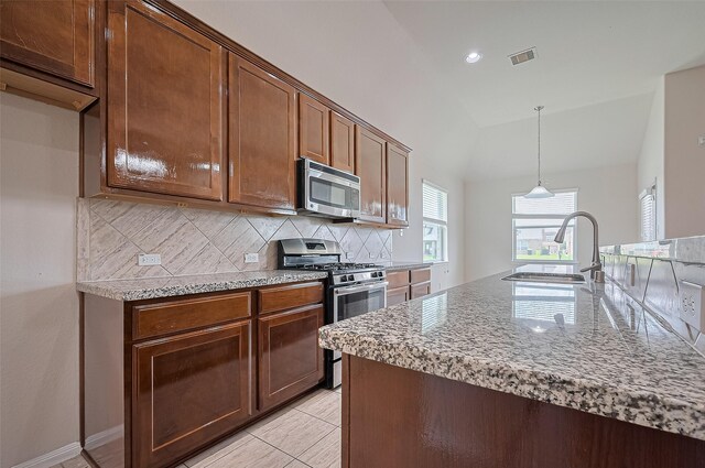 3934 Medici Ct, Missouri City, TX 77459 - kitchen with appliances with stainless steel finishes, decorative backsplash, a sink, lofted ceiling, and light stone counters